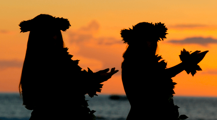 Überdachte Terrasse mit zwei Stühlen und Tisch vor Infinity Pool mit Ausblick auf das Meer, welches von einem Nadelbaum verdeckt wird